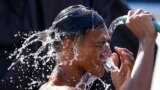 A man douses himself with water along a street as hot temperatures continue in Manila, Philippines, April 26, 2024.