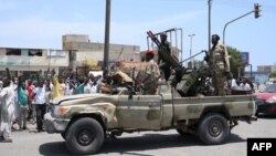 Sudanese greet army soldiers, loyal to army chief Abdel Fattah al-Burhan, in the Red Sea city of Port Sudan on April 16, 2023.