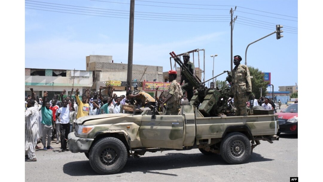 Warga Sudan menyapa tentara, yang setia kepada panglima militer Abdel Fattah al-Burhan, di kota Laut Merah Port Sudan pada 16 April 2023. (Foto: AFP)
