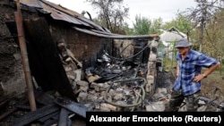 Vladislav Driga, 75, stands next to the ruins of his outbuilding destroyed by recent shelling in Donetsk, Russian-controlled Ukraine, Sept. 1, 2023. 