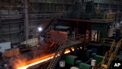 资料照片：2019年7月24日，中国营口一家钢厂内的输送机上炽热的钢卷。（美联社照片）

