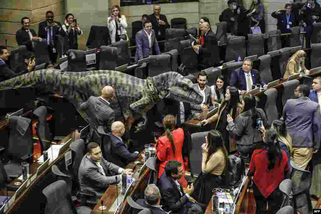 A person in a dinosaur costume makes an appearance at the Colombia Congress during a debate on climate change, in Bogota, June 13, 2023.