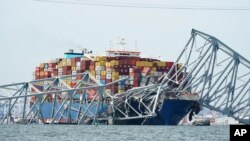 Kapal kargo yang menabrak Jembatan Francis Scott Key Bridge terlihat tersangkut di bawah reruntuhan jembatan itu di Baltimore, Maryland, pada 26 Maret 2024. (Foto: AP/Steve Helber)