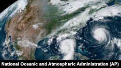 This Aug. 29, 2023, satellite image provided by the National Oceanic and Atmospheric Administration shows Hurricane Idalia, center, approaching Florida's Gulf Coast, and Hurricane Franklin, right, as it moves along the East coast of the U.S. (NOAA via AP)