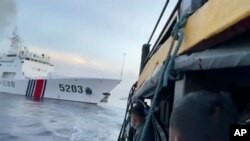 Pelaut Filipina menjaga kapal Garda Pantai China dengan nomor haluan 5203 yang menabrak kapal mereka saat mendekati Second Thomas Shoal, di Laut China Selatan pada 22 Oktober 2023. (Foto: via AP)