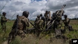 FILE — Ukrainian servicemen prepare to fire at Russian positions from a U.S.-supplied M777 howitzer near Kharkiv, Ukraine, July 14, 2022. Some say the Biden administration could do more to re-arm Ukraine without waiting for congressional approval.