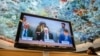U.N. High Commissioner for Human Rights Volker Turk, center, is seen on a TV monitor speaking during a session of the 52nd U.N. Human Rights Council, in Geneva, on March 6, 2023. 