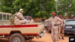 Nigerien national guardsmen sit outside the customs offices in Niamey, Aug. 21, 2023. Around 300 trucks of food and other materials crossed into Niger from Burkina Faso with many arriving in Niamey Sunday, according to a regional custom's official. 