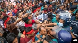 Aktivis bentrok dengan polisi saat menggelar pawai lagu untuk mengenang para korban bentrokan mematikan di seluruh negeri, di Dhaka, Bangladesh, Selasa, 30 Juli 2024. (Rajib Dhar/AP)