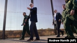 (FILE) President Joe Biden walks along a stretch of the U.S.-Mexico border in Texas.