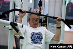 FILE - For resistance training, Toshiyuki Honma, 70, uses a pulldown weight machine as he works out at the Fukagawa Sports Center in Tokyo, June 12, 2024. (AP Photo/Hiro Komae)