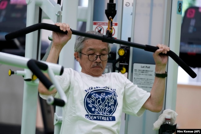 FILE - For resistance training, Toshiyuki Honma, 70, uses a pulldown weight machine as he works out at the Fukagawa Sports Center in Tokyo, June 12, 2024. (AP Photo/Hiro Komae)