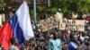 示威人士在尼日尔首都尼亚美举起一面俄罗斯旗帜进行反法和支持政变的游行。（2023年7月30日）
