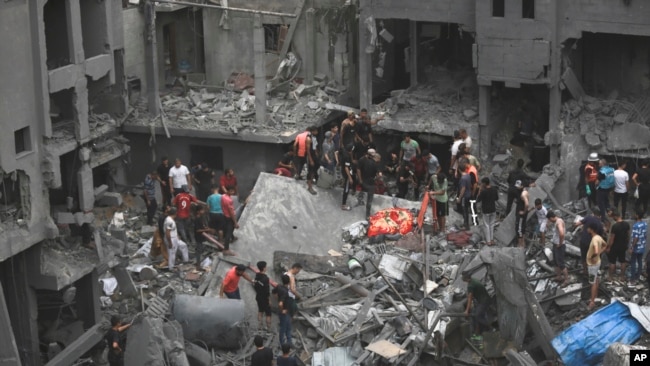 Palestinians inspect the damage of destroyed buildings following Israeli airstrikes on Gaza City, Oct. 27, 2023.