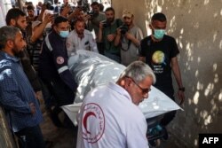 El cuerpo de un miembro del personal de World Central Kitchen es transportado fuera de la morgue de un hospital en Rafah, en el sur de la Franja de Gaza, el 3 de abril de 2024, dos días después de que un convoy de la ONG fuera alcanzado en un ataque israelí.