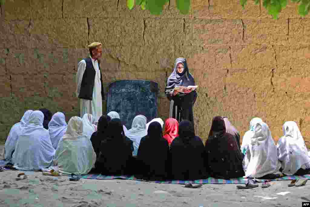 Авганистанските ученички посетуваат час во основно училиште на отворено во областа Хогјани во провинцијата Нангархар