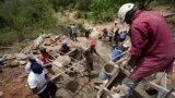 Members of Kyemoo Power, a self-help group, construct a sand dam in Makueni County, Kenya on Thursday, Feb. 29, 2024. Building sand dams helps minimize water loss through evaporation and recharges groundwater. (AP Photo/Brian Inganga)