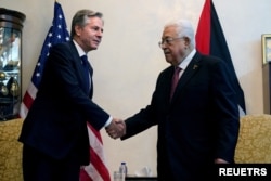 U.S. Secretary of State Antony Blinken shake hands with Palestinian President Mahmoud Abbas, in Amman, Jordan, Oct. 13, 2023. Jacquelyn Martin/Pool via REUTERS