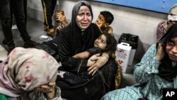 Palestinians wounded at Ahli Arab hospital sit at al-Shifa hospital, in Gaza City, Gaza Strip, Oct. 17, 2023. The Hamas-run Health Ministry says an Israeli airstrike caused an explosion, but the Israeli military says it was a misfired Palestinian rocket. 