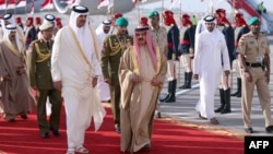 FILE - King of Bahrain, Hamad bin Issa al-Khalifa (C-R) welcomes the Emir of Qatar Sheikh Tamim bin Hamad al-Thani (C-L) upon his arrival for the 37th Gulf Cooperation Council (GCC) summit, Dec. 6, 2016 in the Bahraini capital Manama.