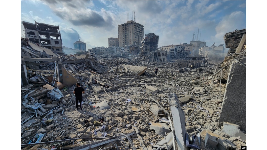 Warga Palestina berjalan melewati puing-puing bangunan yang hancur akibat serangan udara Israel di Kota Gaza, 10 Oktober 2023.