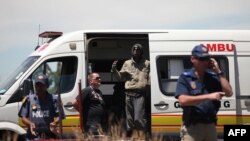 FILE - An miner who was trapped in an illegal gold mine stands in an ambulance near the access site of the mine in Benoni, in the East Rand on Feb. 17, 2014.