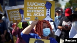 Una mujer sostiene un cartel que dice: "Lucho por la vida, defiendo el agua" durante una protesta para conmemorar el día Mundial del Agua, en San Salvador, el 22 de marzo de 2022.