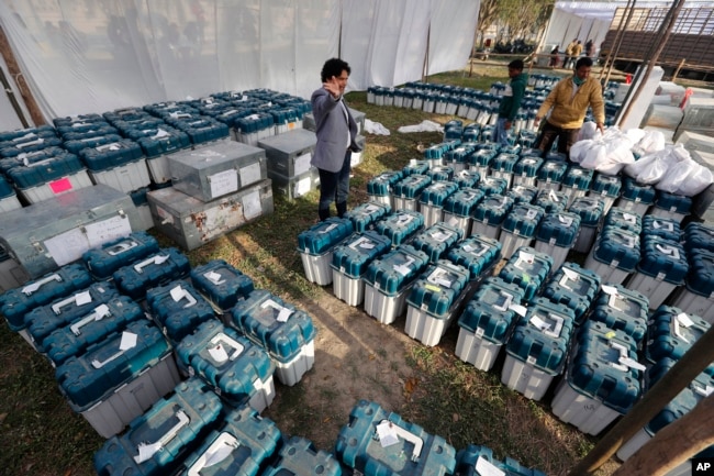 FILE - Election officials gather at a distribution center to receive electronic voting machines and other polling material during polling for Uttar Pradesh state elections in Lucknow, India, Tuesday, Feb. 22, 2022. (AP Photo/Rajesh Kumar Singh, File)