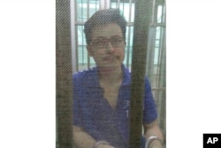 FILE - Yang Maodong, better known by his penname Guo Feixiong, sits in a detention center in Guangzhou, China, in 2014.