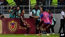 El venezolano Darwin Machis, izquierda, celebra con sus compañeros de equipo después de anotar el tercer gol de su equipo contra Chile durante un partido de fútbol de clasificación para la Copa Mundial de la FIFA 2026.