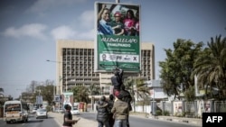 FILE - Supporters of Zambian President elect for the opposition party United Party for National Development (UPND) Hakainde Hichilema remove a poster of the former president Edgar Lungu from a pole in Lusaka, Aug. 16, 2021. 