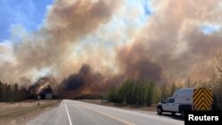 Smoke column rises from a wildfire near Wildwood, Alberta, Canada, May 5, 2023. 