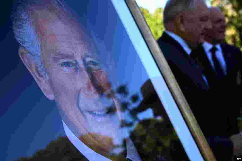 Guests take selfies with the portrait of Britain's King Charles III during a tree-planting ceremony at the Government House in Sydney on May 6, 2023, ahead of the coronation. 