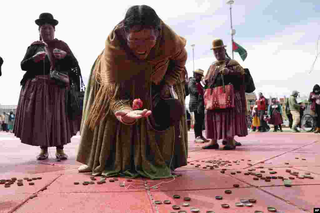 An Aymara woman plays with a spinning top during activities marking the anniversary of the founding of the city of El Alto, Bolivia, March 5, 2023.