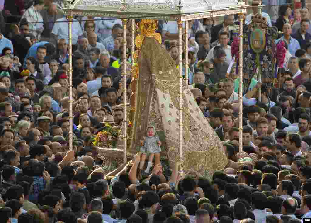 Аџиите ставаат бебе против ликот на Богородица во селото Ел Росио во андалузиската провинција Хуелва, Шпанија, за време на годишниот аџилак на Ел Росио.