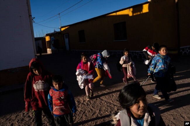 FILE - Children leave at the end of the school day in Huancar, Jujuy Province, Argentina, Tuesday, April 25, 2023. The Andean town is prospering because of the work available in nearby lithium mines. (AP Photo/Rodrigo Abd)