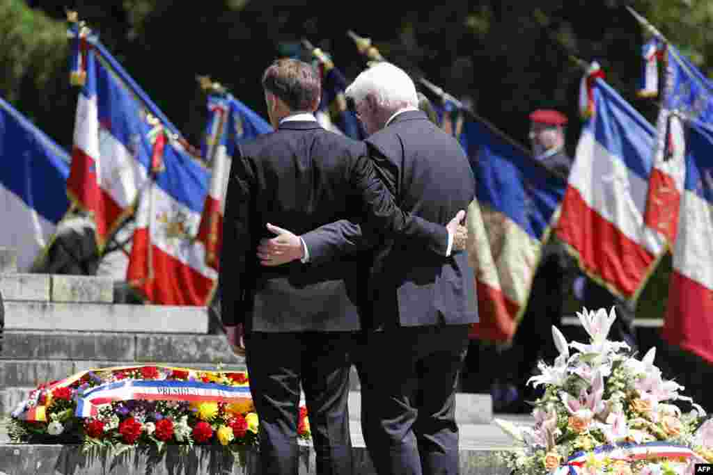 French President Emmanuel Macron, left, and German President Frank-Walter Steinmeier pay their respects during a ceremony marking the 80th anniversary of the massacre of 643 persons by Nazi German forces, in Oradour-sur-Glane, southwestern France. (Photo by Ludovic MARIN / POOL / AFP)