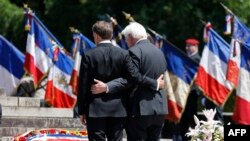 French President Emmanuel Macron, left, and German President Frank-Walter Steinmeier pay their respects during a ceremony marking the 80th anniversary of the massacre of 643 persons by Nazi German forces, in Oradour-sur-Glane, southwestern France. (Photo by Ludovic MARIN / POOL / AFP)
