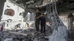 Palestinians stand in the ruins of a home after an overnight Israeli strike in Rafah, southern Gaza Strip, May 3, 2024.