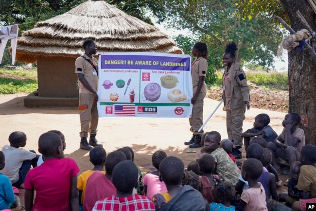 Staff from the Mines Advisory Group (MAG) teach children about the risks of unexploded mines, in Moli village, Eastern Equatoria state, in South Sudan Friday, May 12, 2023. (AP Photo/Sam Mednick)