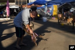 A man and his dog reunite at a shelter providing refuge for dogs evacuated from areas flooded by heavy rains, in Canoas, Rio Grande do Sul state, Brazil, May 9, 2024.