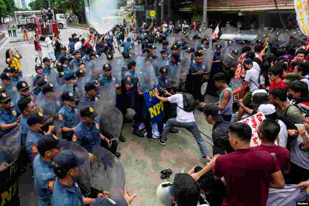 Police officers block Filipino activists from marching towards the U.S. Embassy during a Labor Day protest in Manila, Philippines.