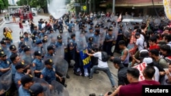 Police officers block Filipino activists from marching towards the US Embassy during a Labor Day protest in Manila, May 1, 2024.