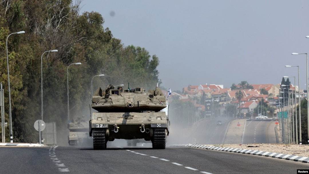 Israeli tanks drive on a road near Sderot in southern Israel, following a mass infiltration by Hamas gunmen from the Gaza Strip, Oct. 8, 2023. 