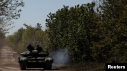 Prajurit Ukraina mengendarai tank menuju kota garis depan Bakhmut, di tengah serangan Rusia terhadap Ukraina, di wilayah Donetsk, Ukraina 12 Mei 2023. (REUTERS/Sofiia Gatilova)