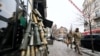 Ukrajinski vojnici prolaze pored improvizovane jelke napravljene od čahura granata i druge municije, ispred kafea u Kijevu, 18. decembra 2023. 