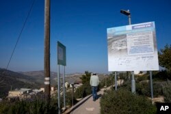 Seorang pria berjalan di pos terdepan Yahudi Tepi Barat Givat Harel, Selasa, 14 Februari 2023. (AP/Ariel Schalit)