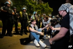 Protesters sit in the street during a demonstration near the Democratic National Convention, Aug. 22, 2024, in Chicago.