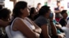 Migrants watch the US presidential debate in a shelter for migrants waiting to apply for asylum, June 27, 2024, in Tijuana, Mexico. 