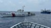 FILE - A Chinese coast guard ship, left, with a Chinese militia vessel, right, blocks Philippine coast guard ship BRP Sindangan as it tried to head towards Second Thomas Shoal at the disputed South China Sea during rotation and resupply mission on Oct. 4, 2023. 